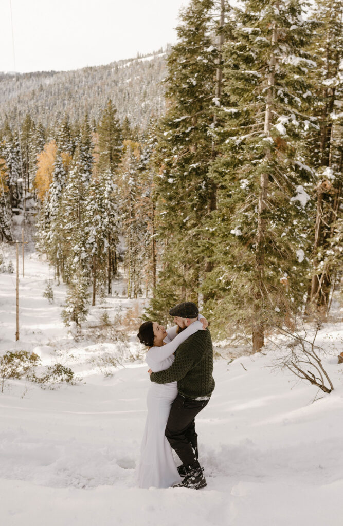 bride and groom smiling and hugging overlooking the trees in Tahoe