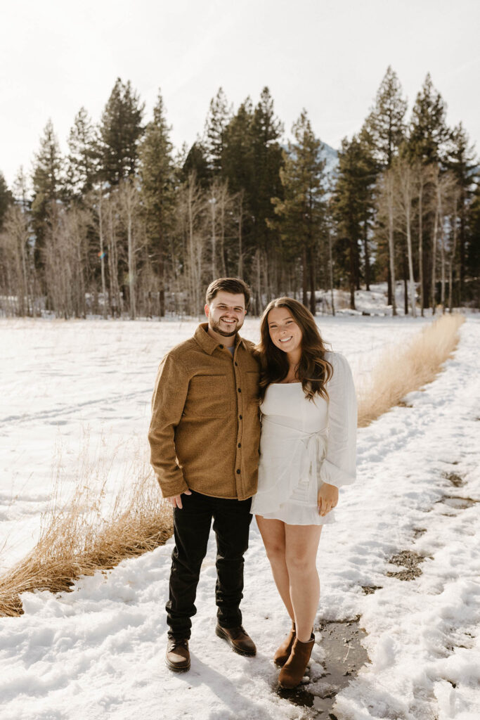 couple standing in the snow in lake tahoe smiling
