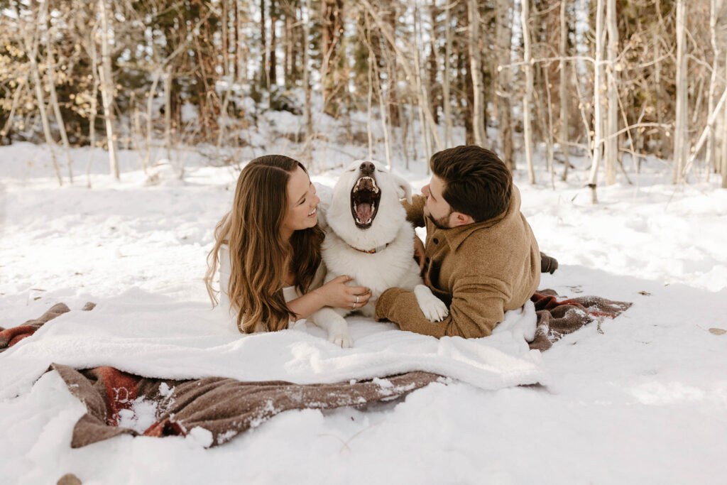 couple laughing as their dog yawns 