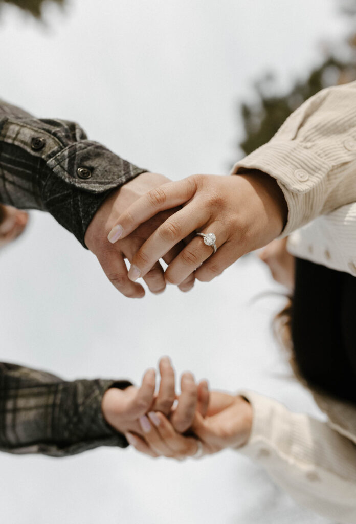 couple holding hands, showing rings