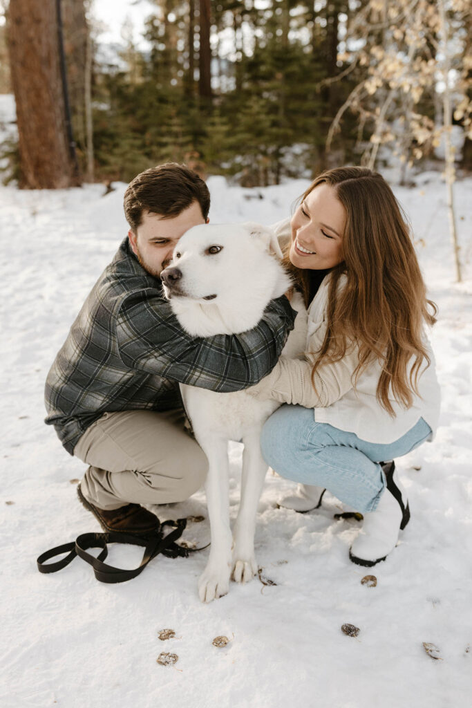 couple hugging their dog in the snow in lake tahoe