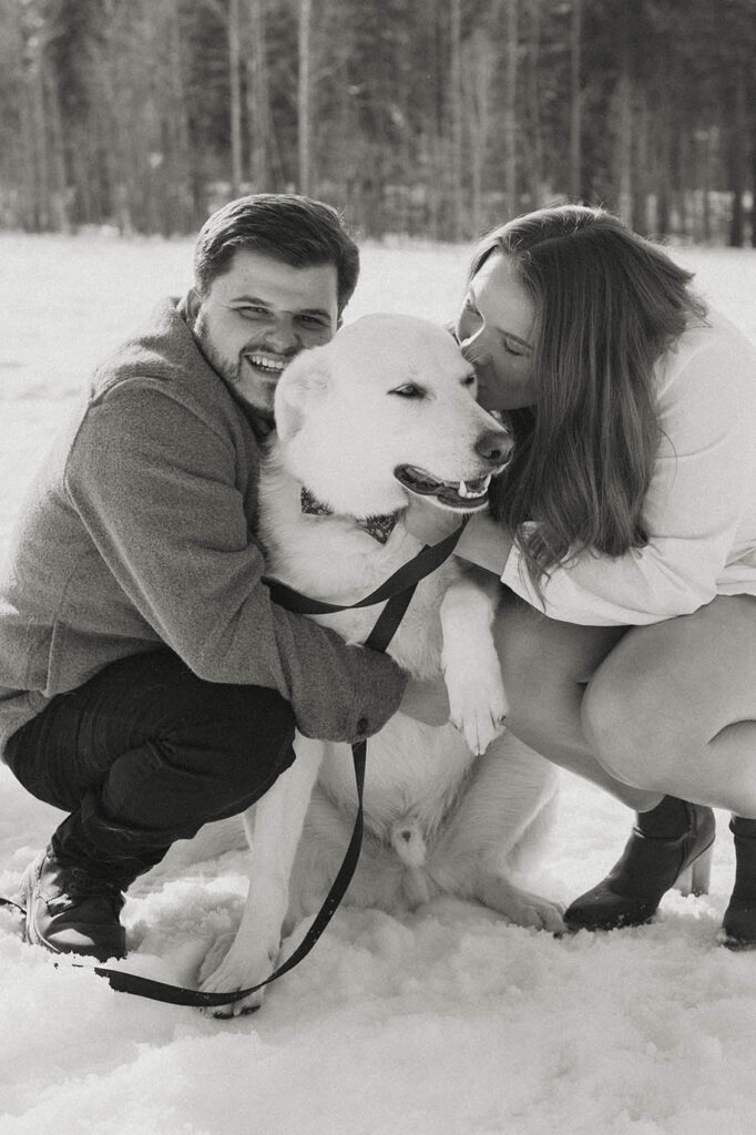 couple hugging dog and smiling