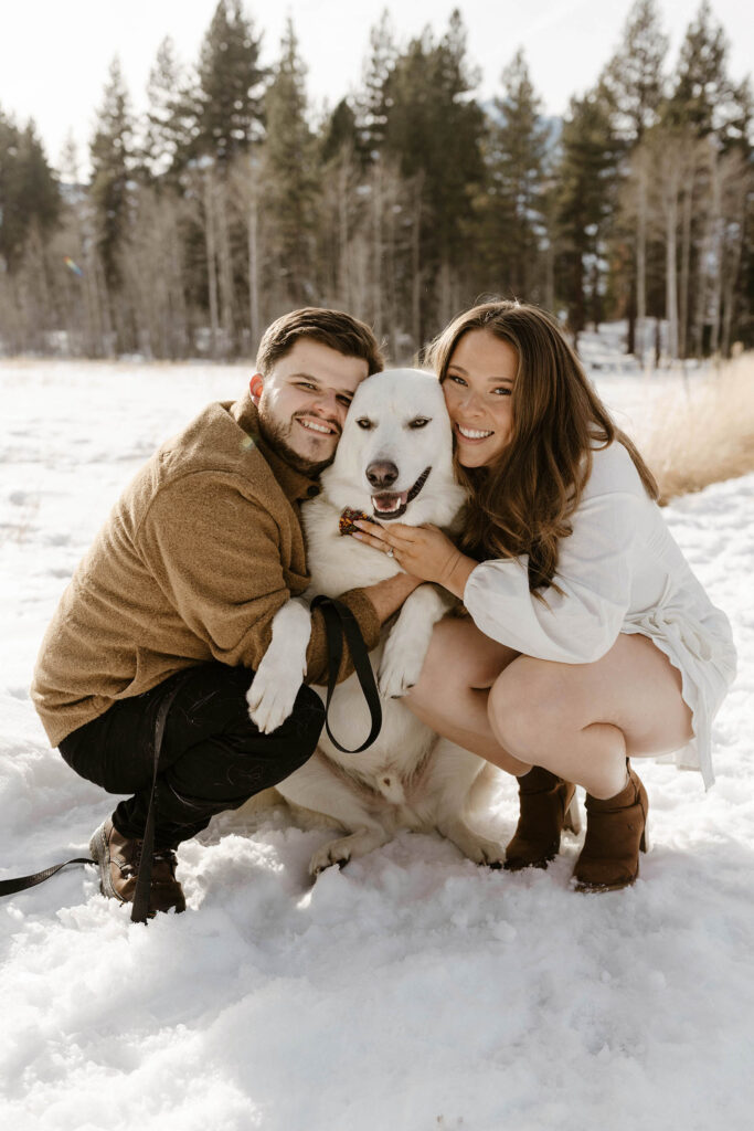 engagement couple smiling with their dog in lake tahoe
