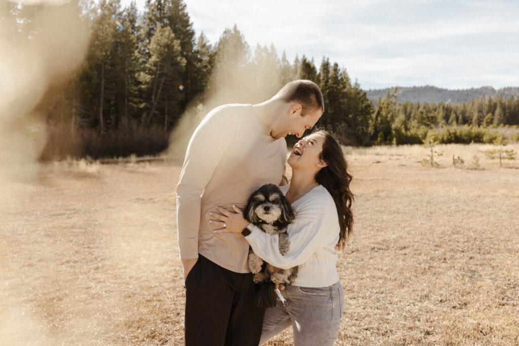 engagement couple smiling with their dog together