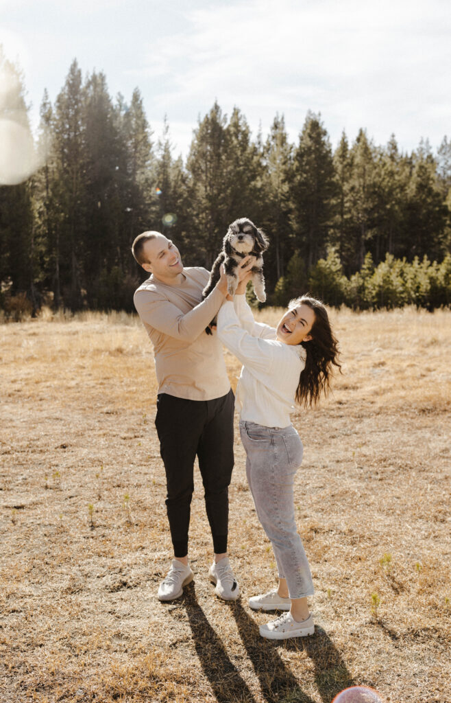 couple holding up their dog at Mount Rose Meadows like the lion king