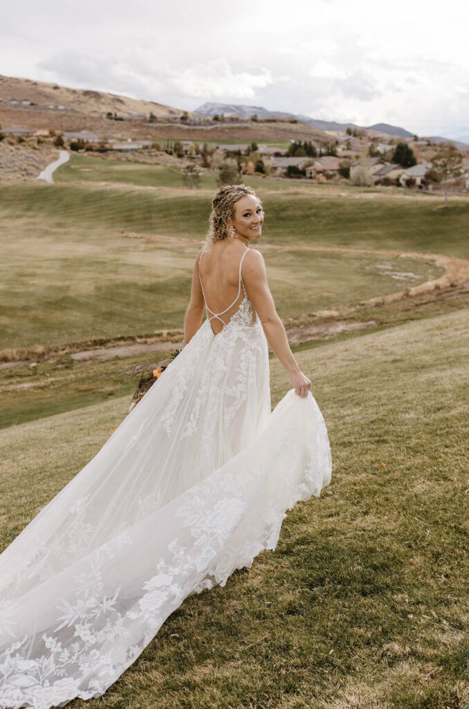 bride looking back and smiling on the grass at tuscan falls