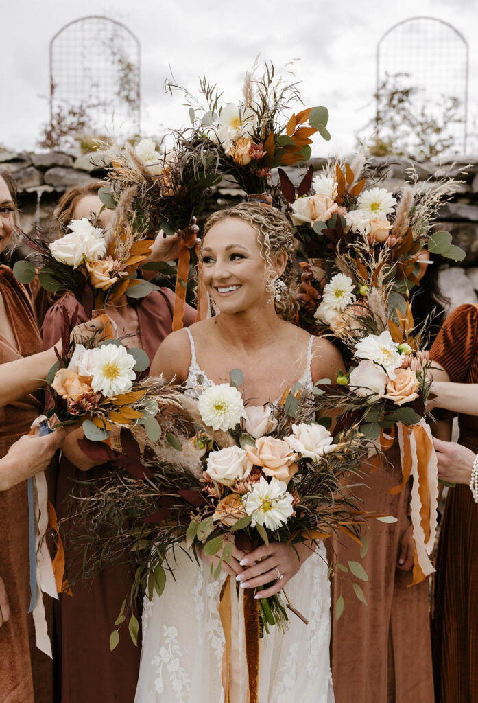 bride surrounded by burgundy bouquets at tuscan falls wedding
