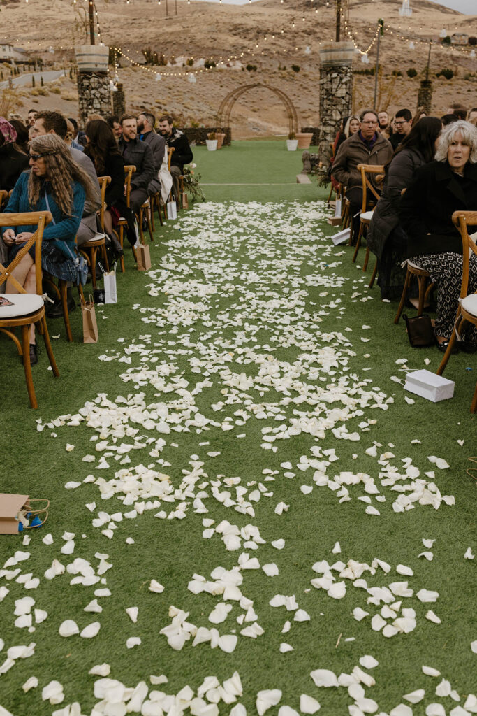 white rose petals in the aisle at tuscan falls wedding ceremony