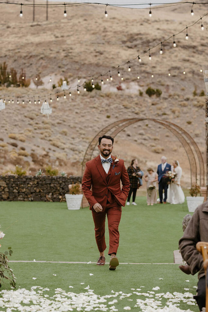groom smiling and walking down the aisle at tuscan falls wedding