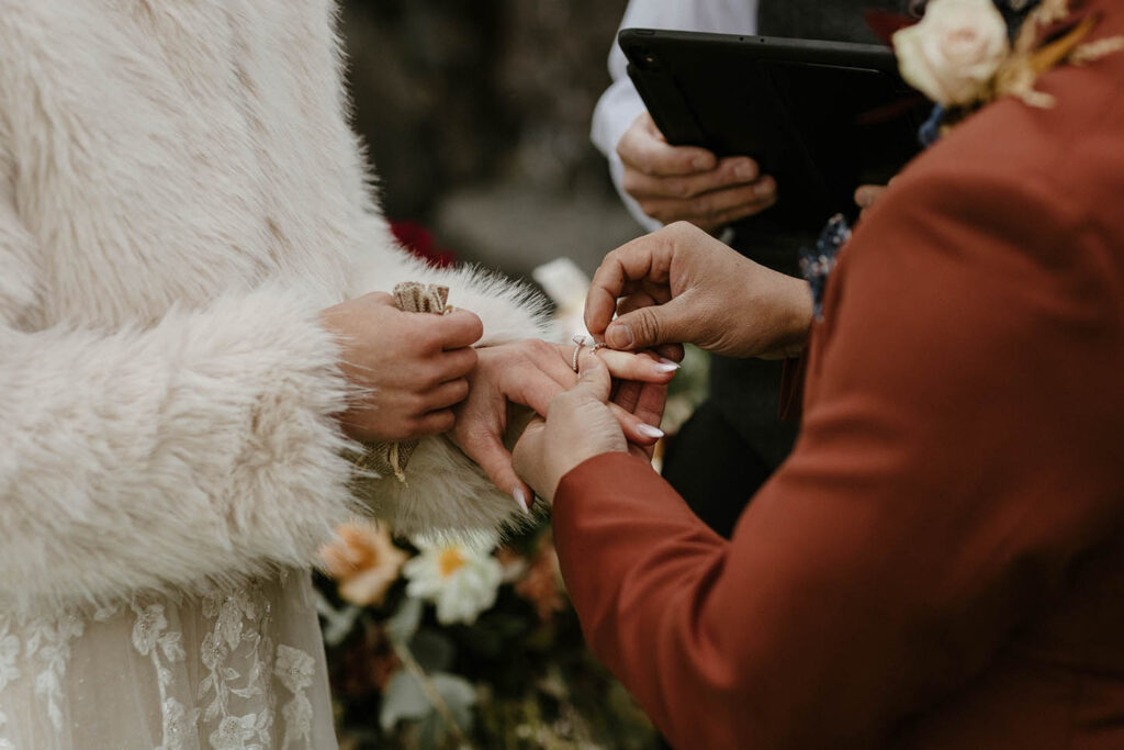 groom putting a ring on his bride during their wedding ceremony