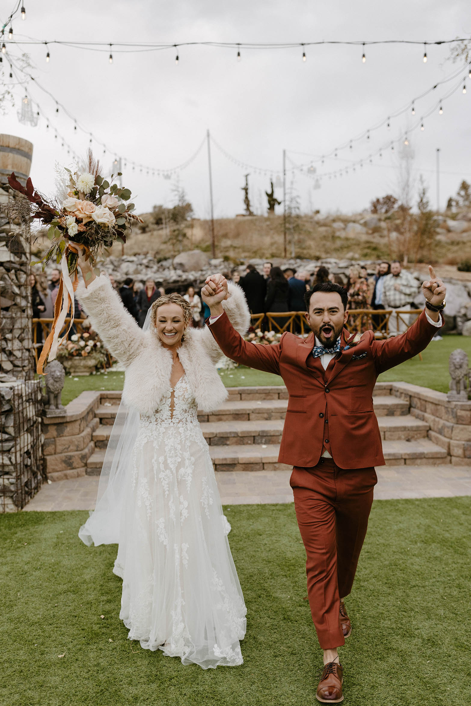 bride and groom cheering with hands in the air