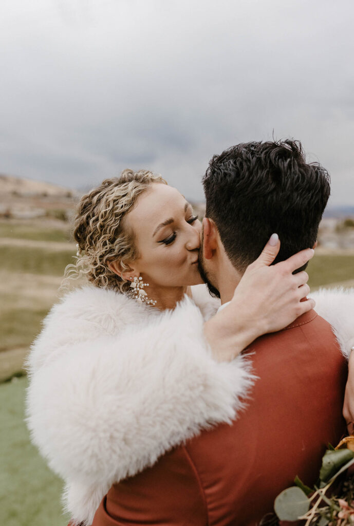bride kissing the groom's cheek at tuscan falls wedding