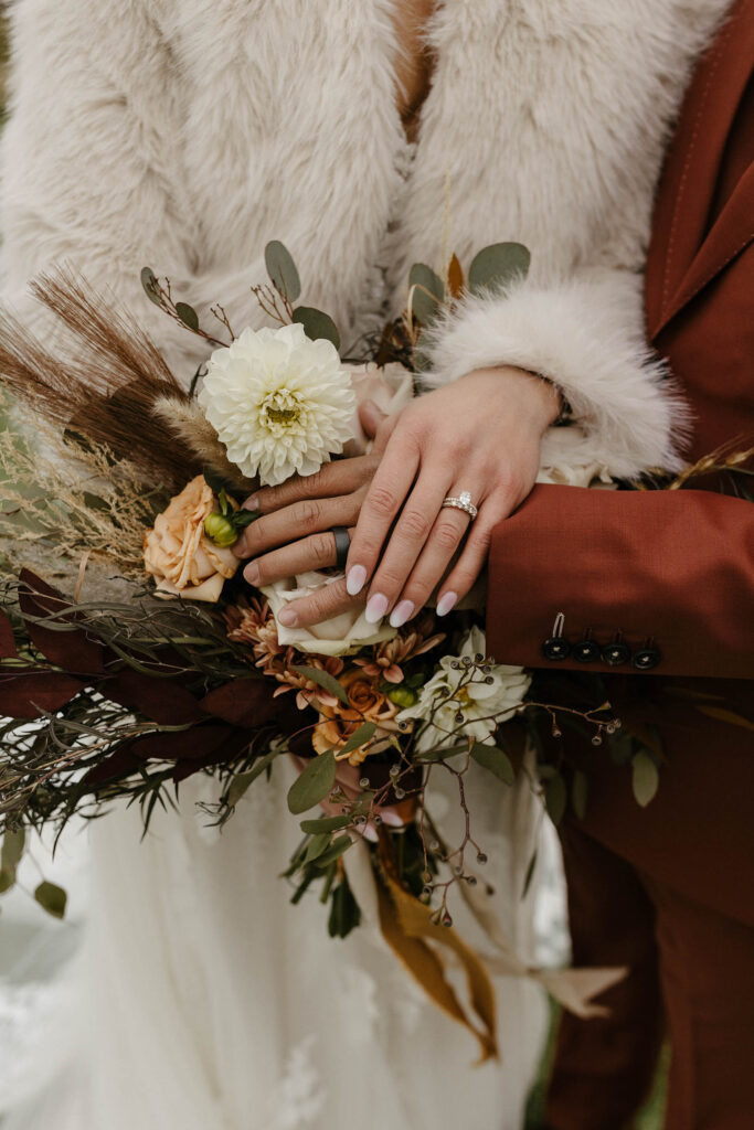 bride and groom showing rings and bouquet at tuscan falls wedding