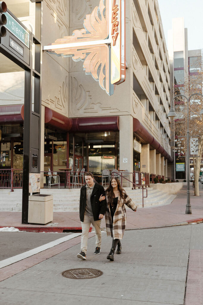 couple walking across the street in downtown reno for their engagement photos