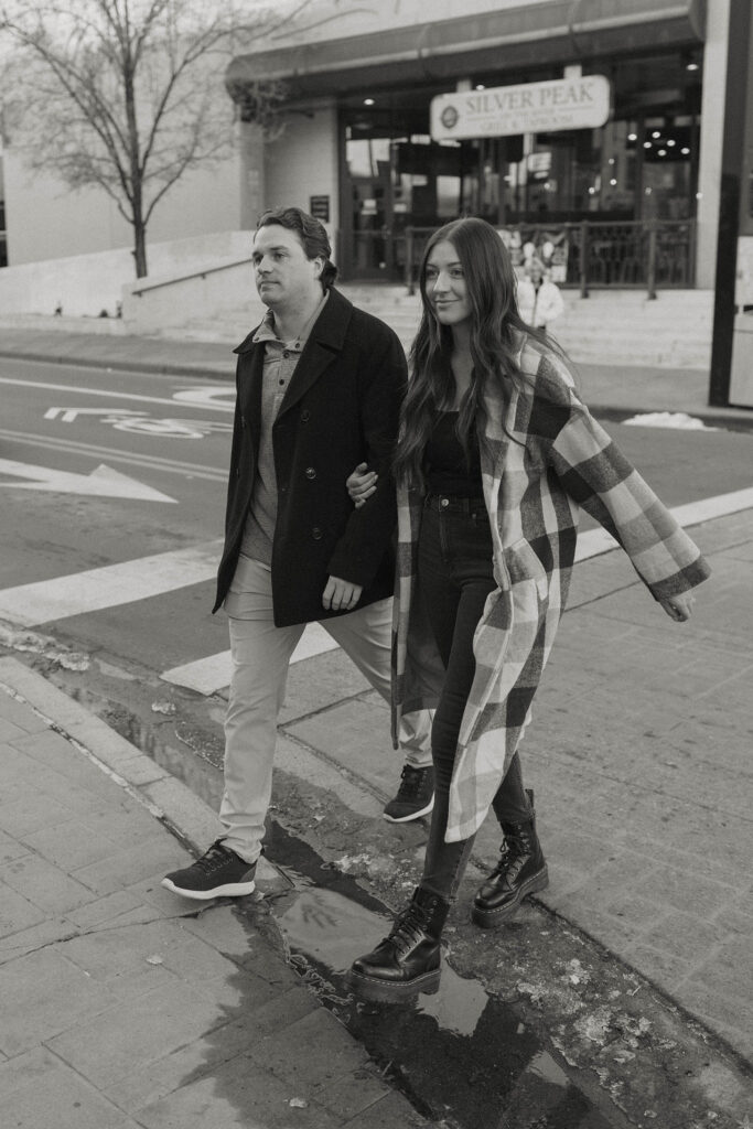 couple walking across the street in downtown reno for their engagement photos