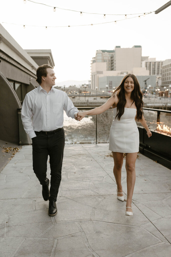 engagement couple walking in nice clothing in downtown reno