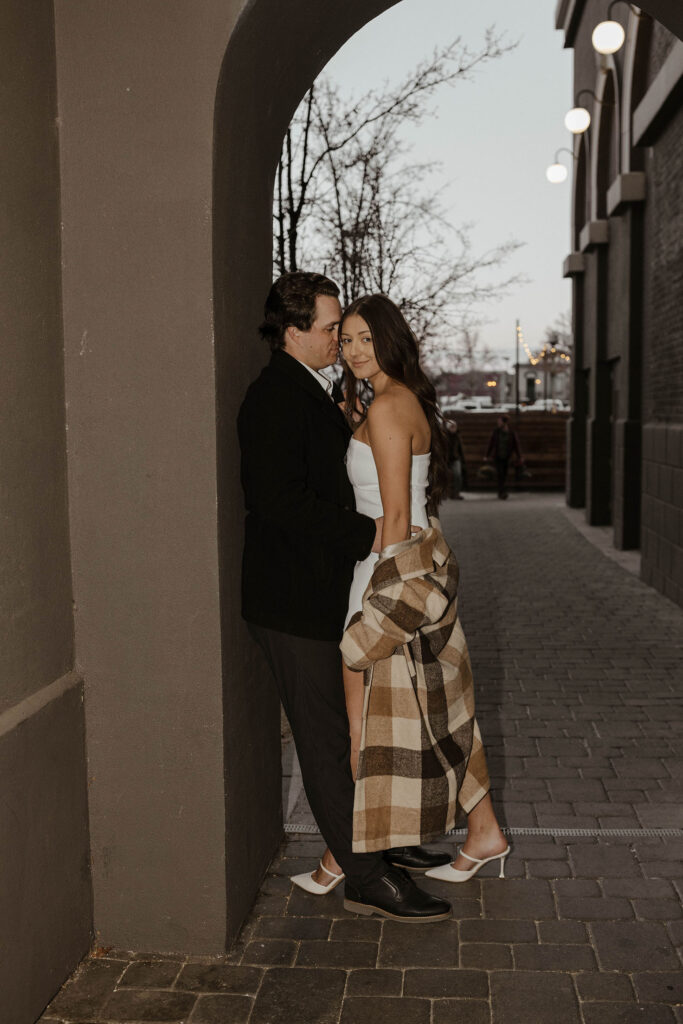 engagement couple leaning against a building in downtown reno
