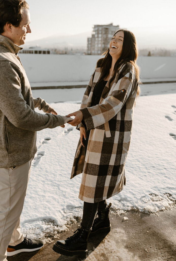 couple laughing together on a snowy rooftop in reno
