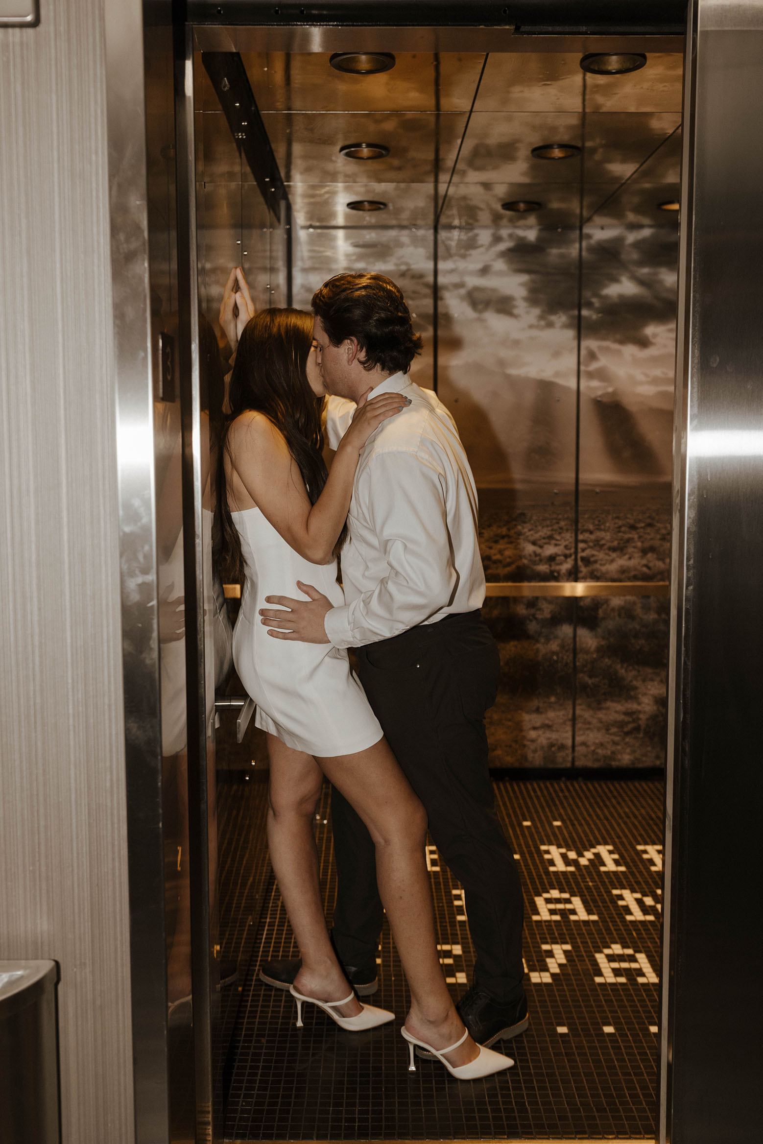 couple kissing in an elevator in reno for their downtown engagement photos