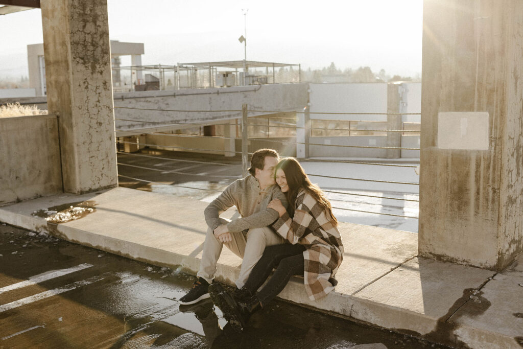 couple sitting on a rooftop for their downtown reno engagement photos