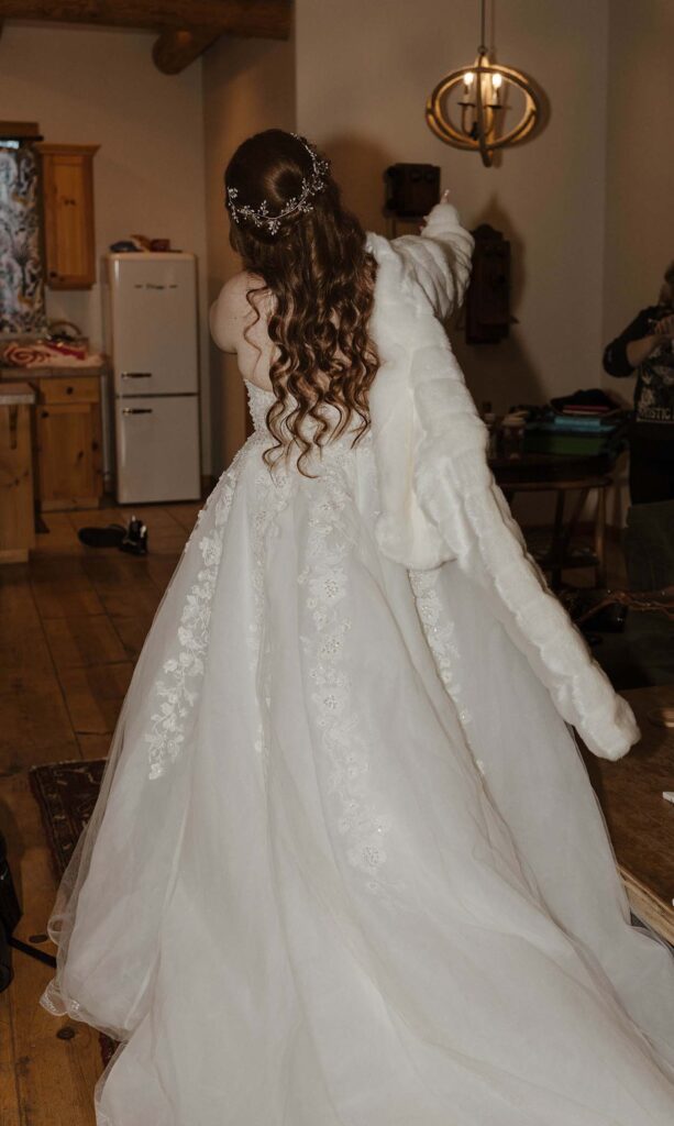 bride putting on a fur coat over her wedding dress