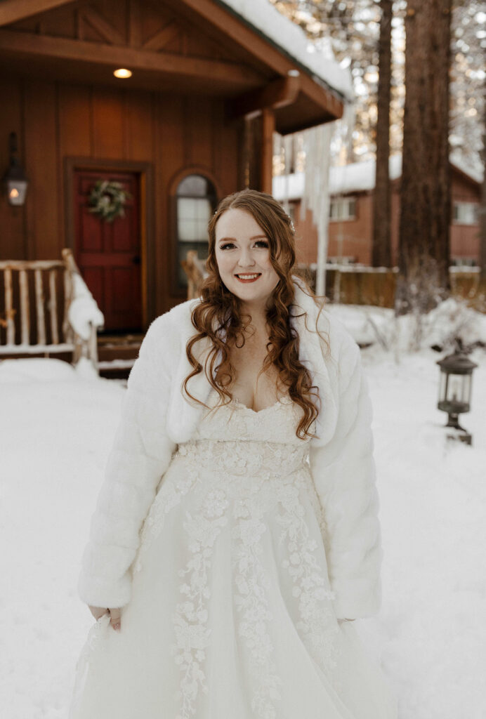 winter elopement bride smiling outside a cabin in lake tahoe
