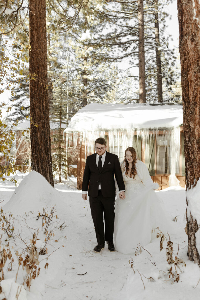 elopement couple walking through the snow in the winter in lake tahoe
