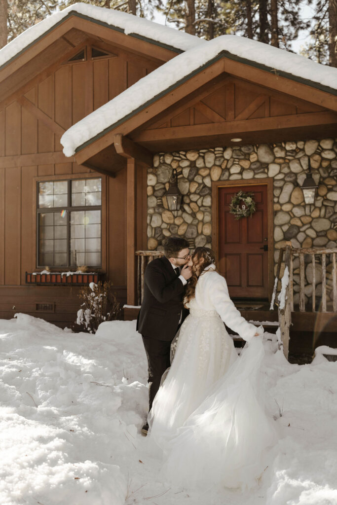 elopement couple kissing in front of a cabin in lake tahoe