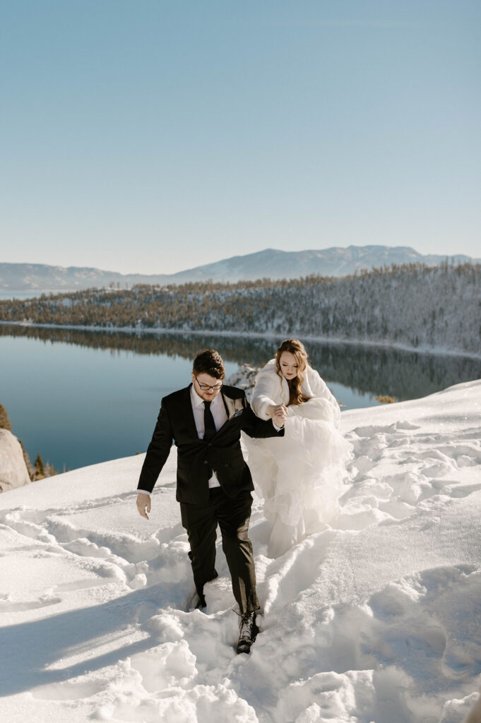 winter elopement couple hiking in the snow overlooking lake tahoe