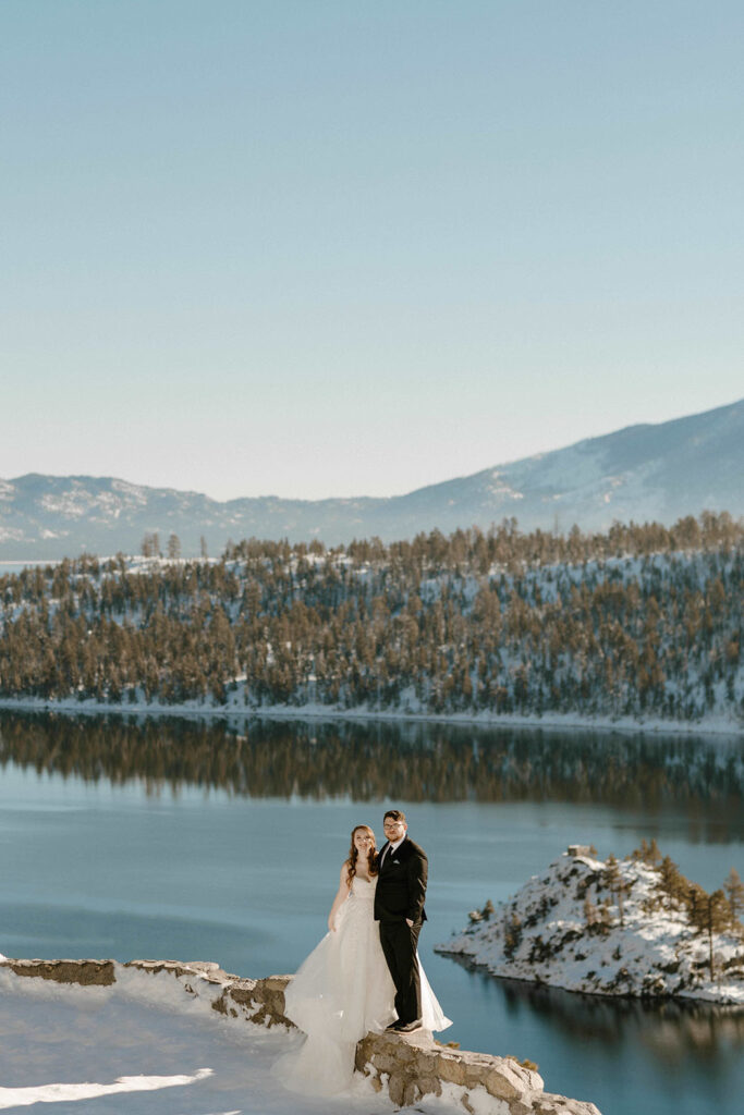 elopement couple smiling at the camera overlooking the blue waters in lake tahoe