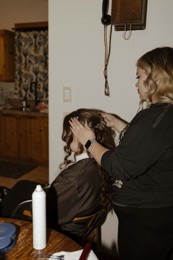 bride getting her hair done for her winter elopement