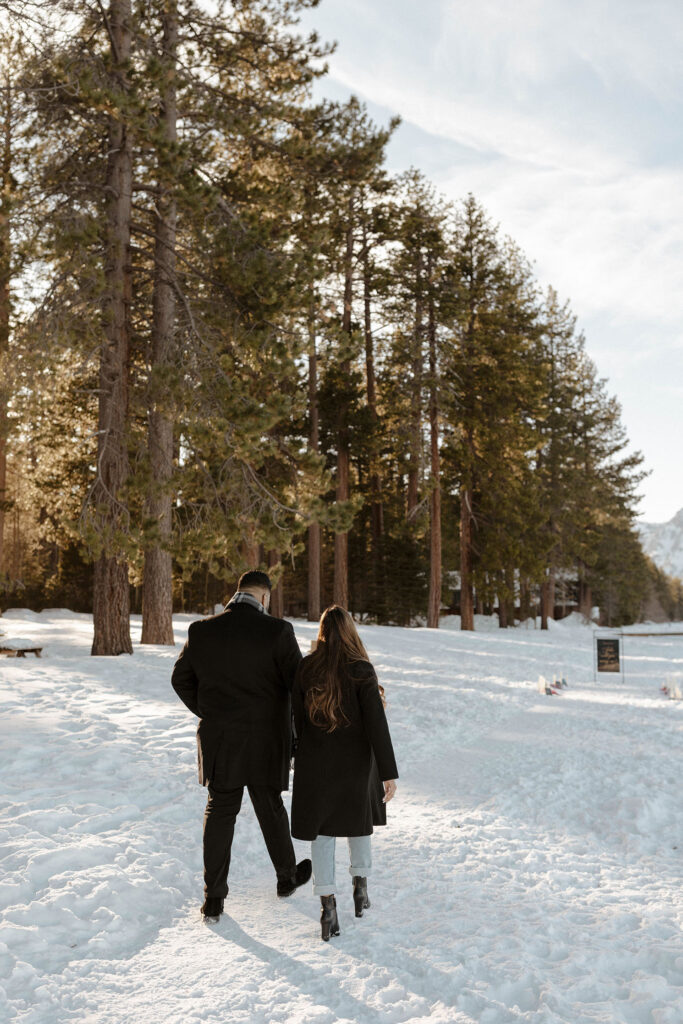 couple walking in the snow up to their proposal spot in south lake tahoe