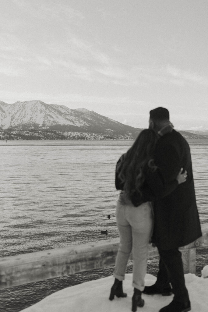 couple hugging looking at the mountains in the distance in lake tahoe