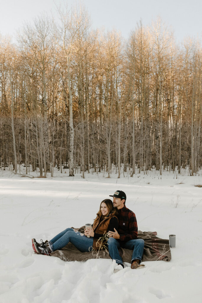 couple sitting on a blanket in the winter in lake tahoe 