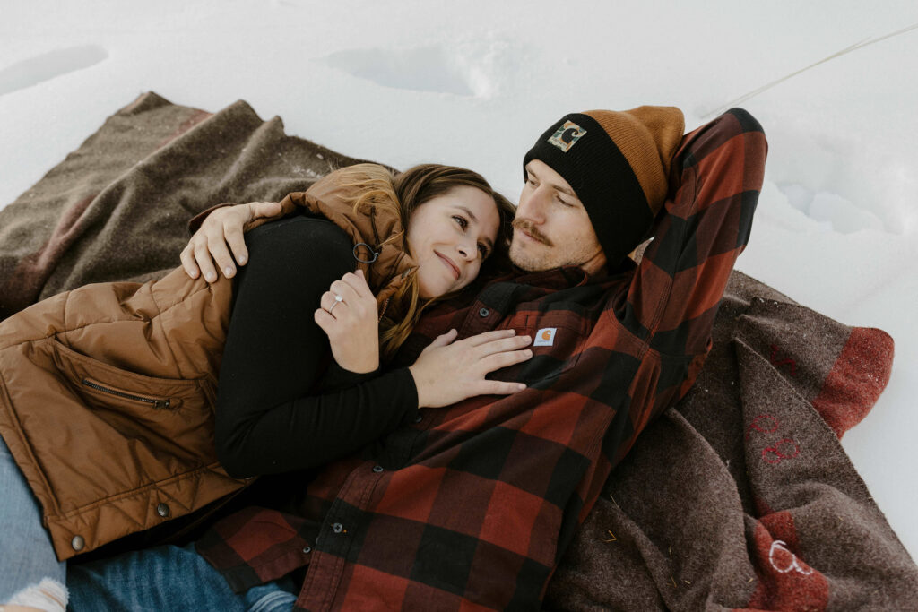 couple hugging on a blanket in the snow in lake tahoe
