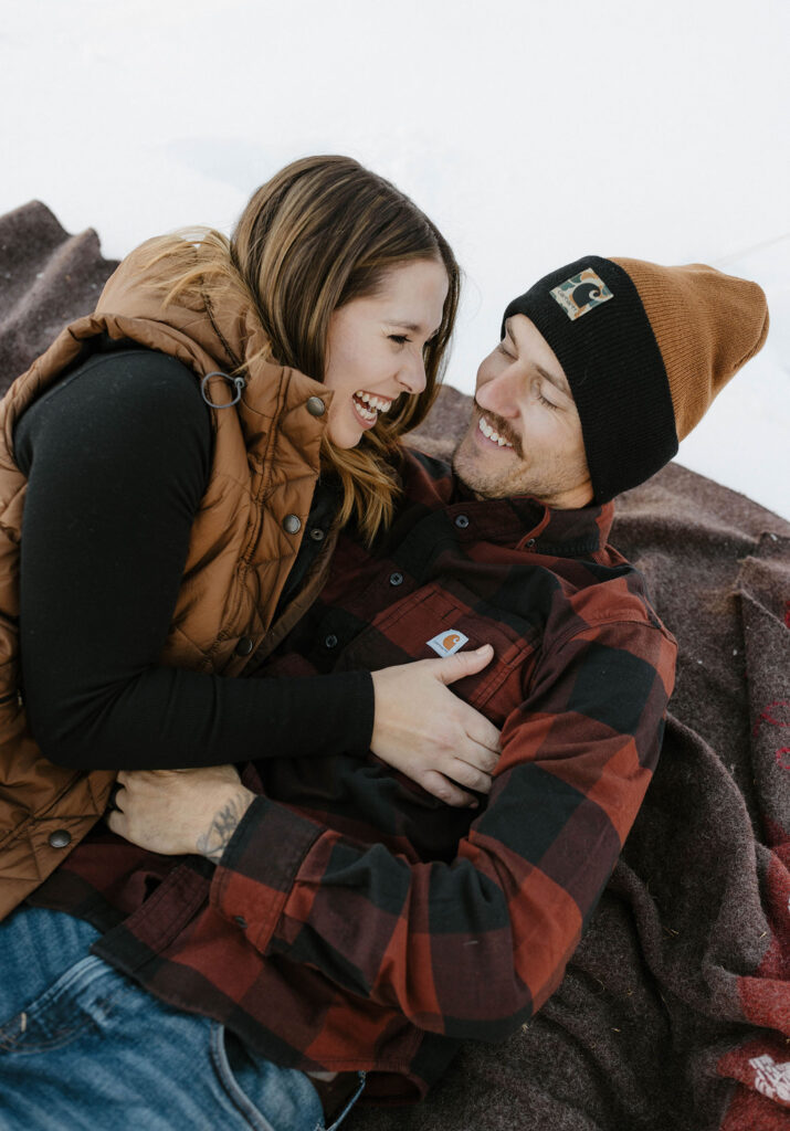 couple tickling each other and laughing in the snow in lake tahoe