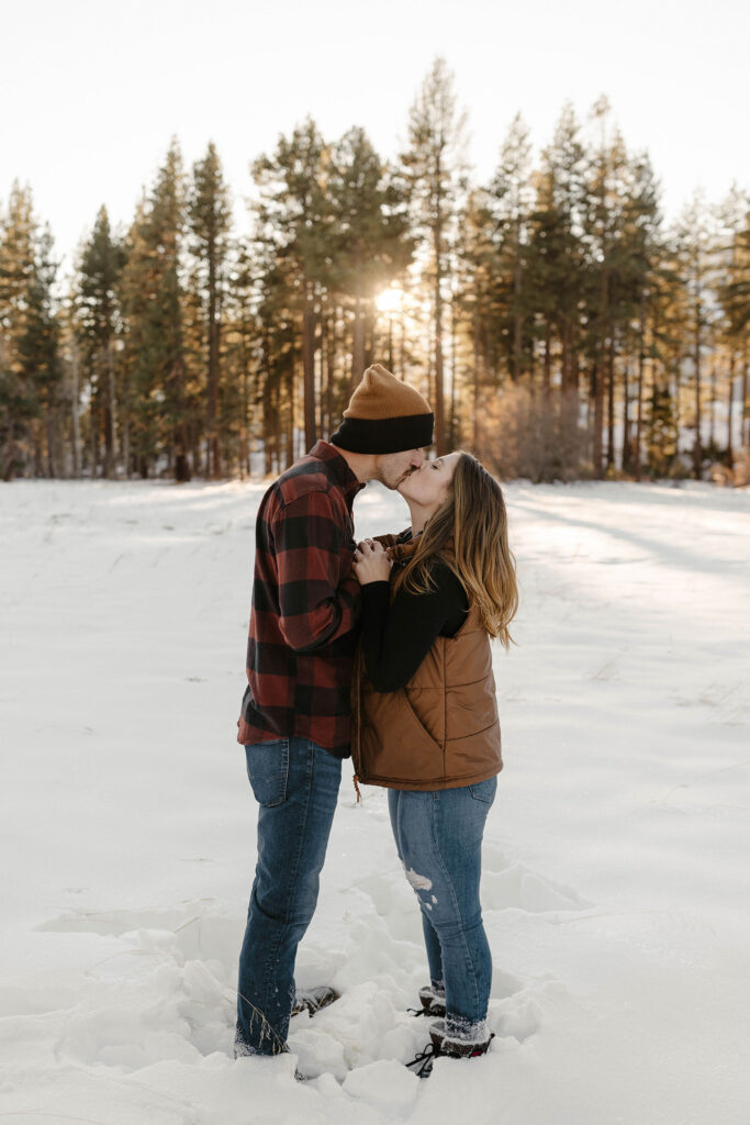 couple kissing in the winter in lake tahoe while standing in the snow