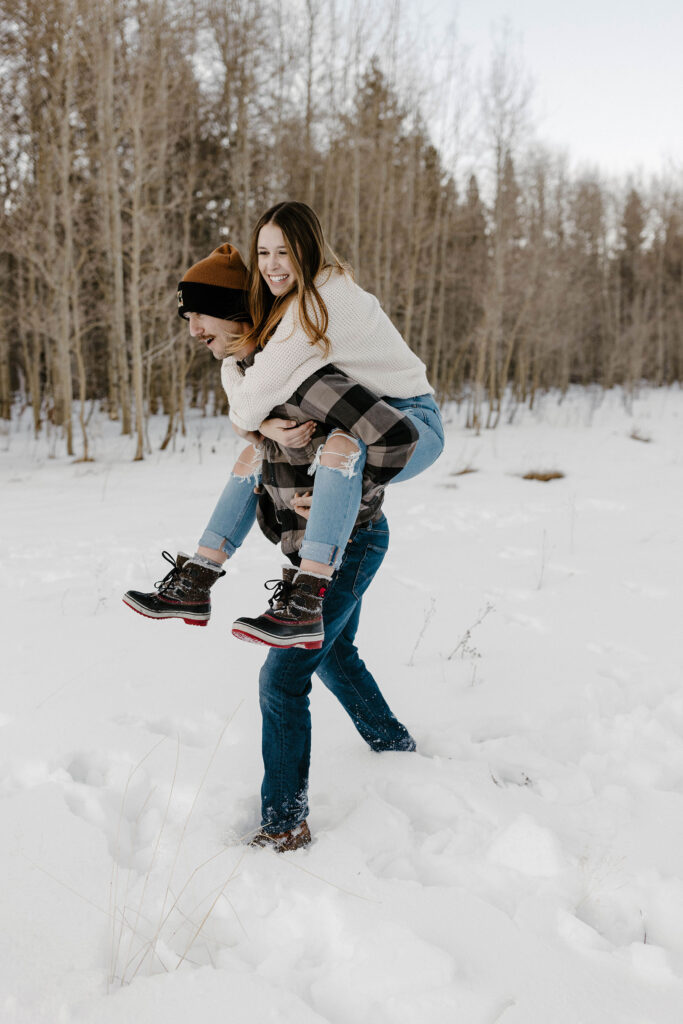 couple giving a piggy back ride in the snow in lake tahoe