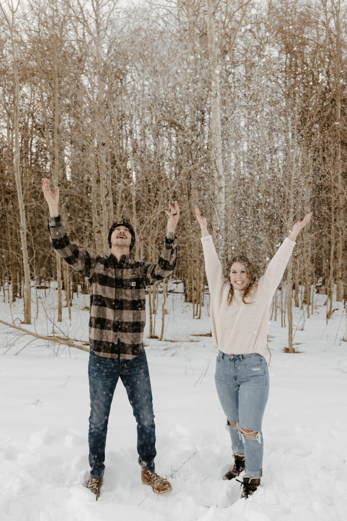 couple throwing snow in the air in the winter in lake tahoe