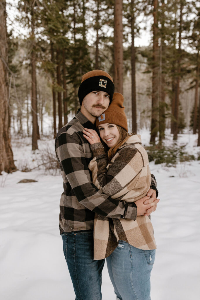 couple hugging and smiling at the camera in the winter in lake tahoe