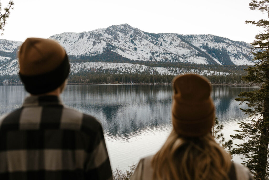 couple blurry overlooking the mountains with snow on them in lake tahoe