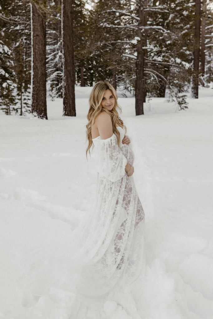 winter maternity photos of woman in a lace dress