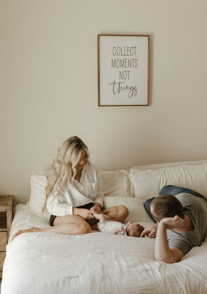 Couple playing with baby while lying on bed inside home