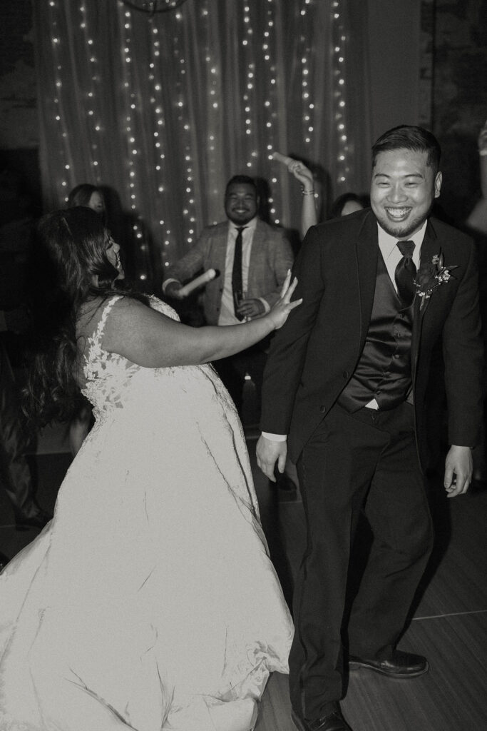 bride and groom dancing and laughing at winter wedding at the whitney peak hotel