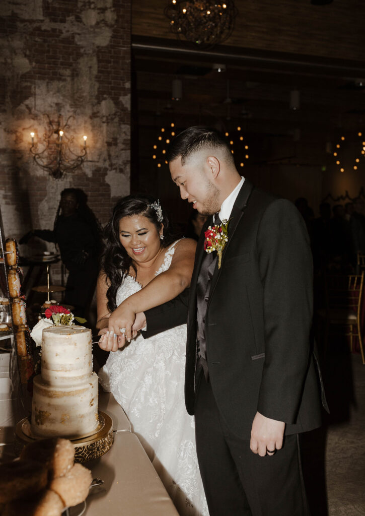 bride and groom cutting their cake together at winter wedding at the whitney peak hotel