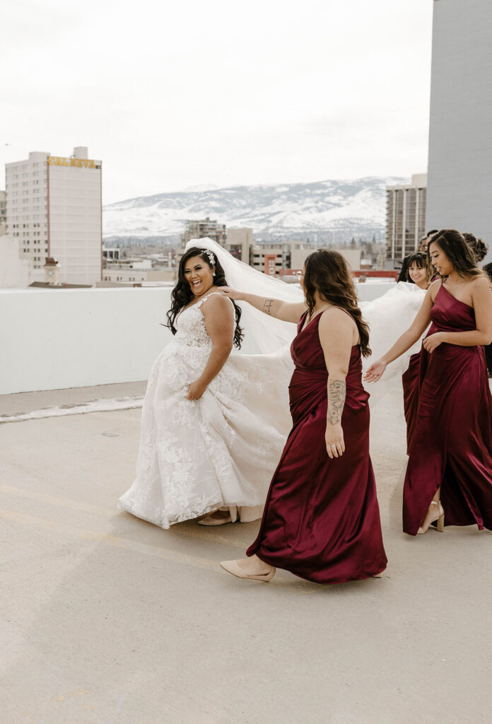 bridesmaids helping carry the brides dress at a winter wedding at the whitney peak hotel