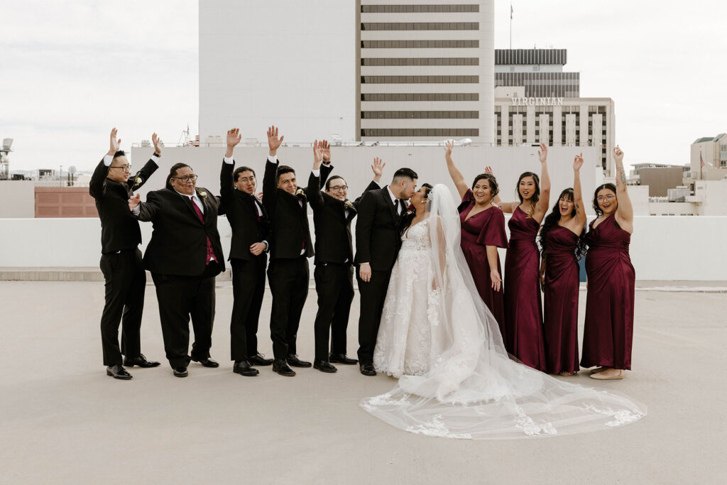 bridal party cheering as the bride and groom kiss at a winter wedding at the whitney peak hotel
