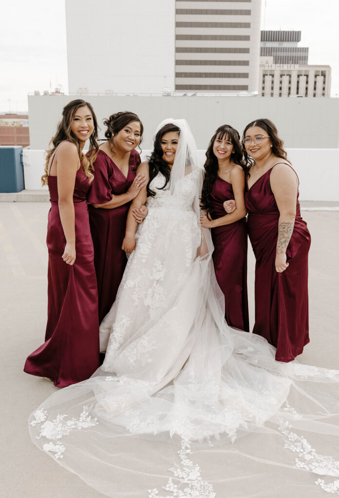 bridesmaids in maroon dresses smiling at a winter wedding at the whitney peak hotel
