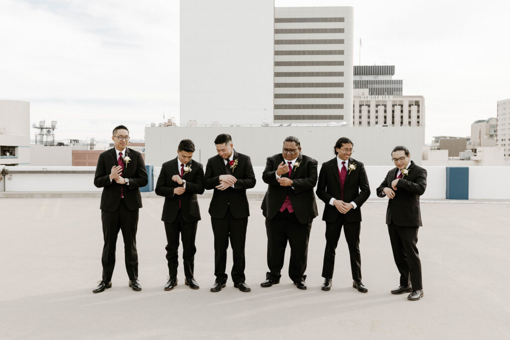 groomsmen in maroon details adjusting their outfits at a winter wedding at the whitney peak hotel