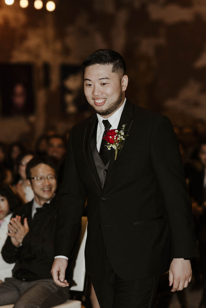 groom smiling and walking down the aisle for a winter wedding at the whitney peak hotel